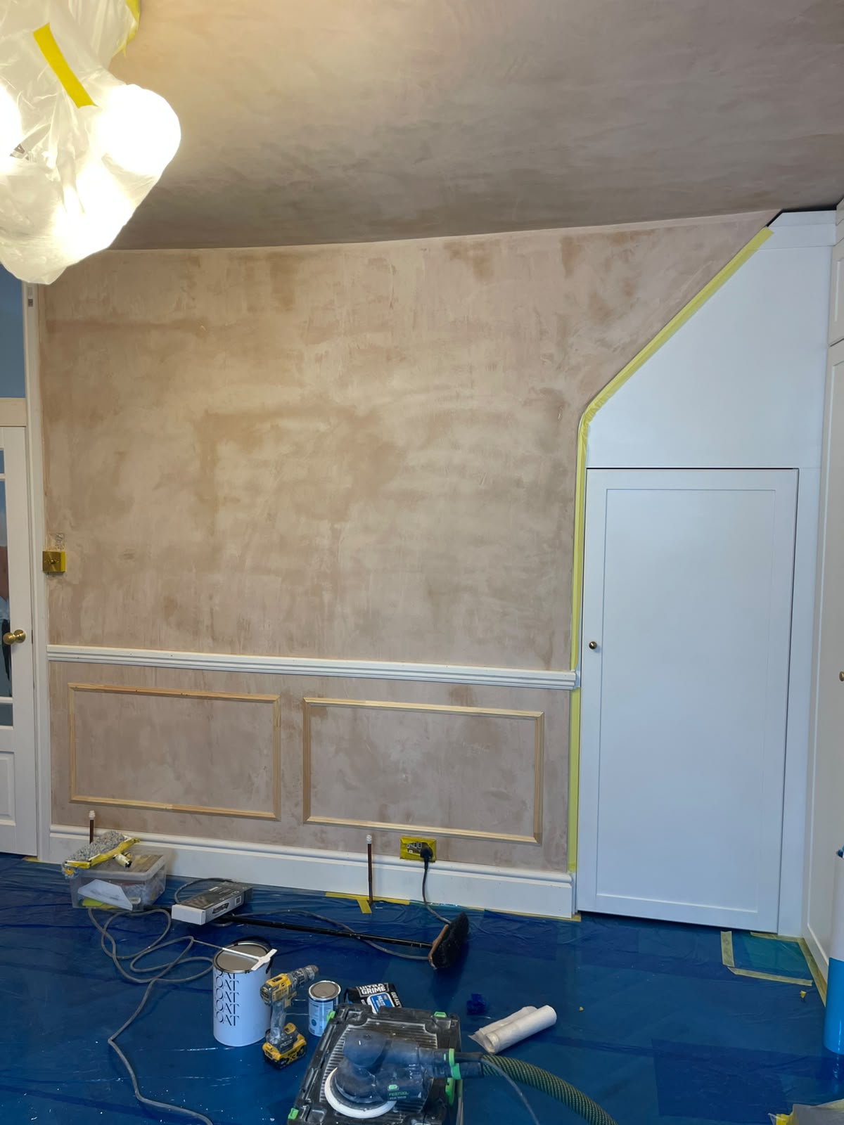 Freshly plastered wall with newly installed timber wainscoting panels ready for paint