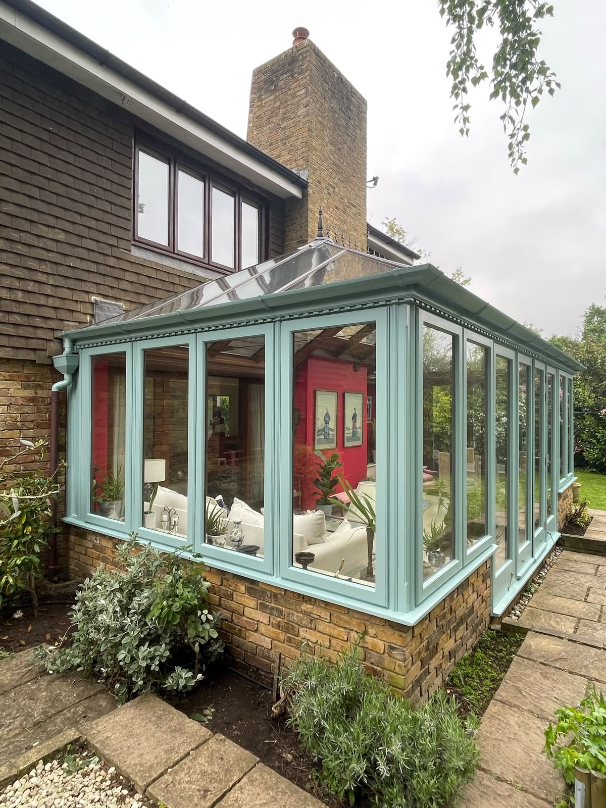 Freshly painted duck-egg conservatory with decorative cornice and roof crest