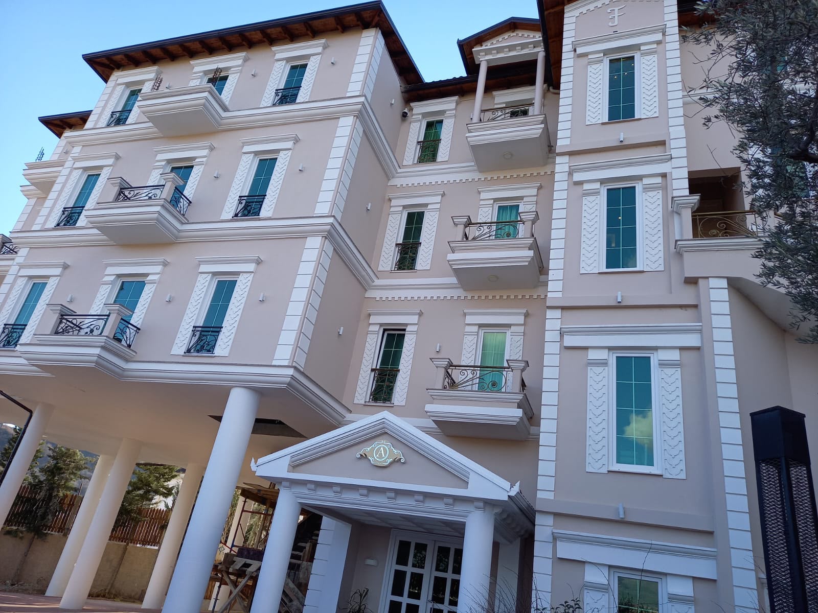 Large stucco villa with freshly painted cream facade and crisp white detailing
