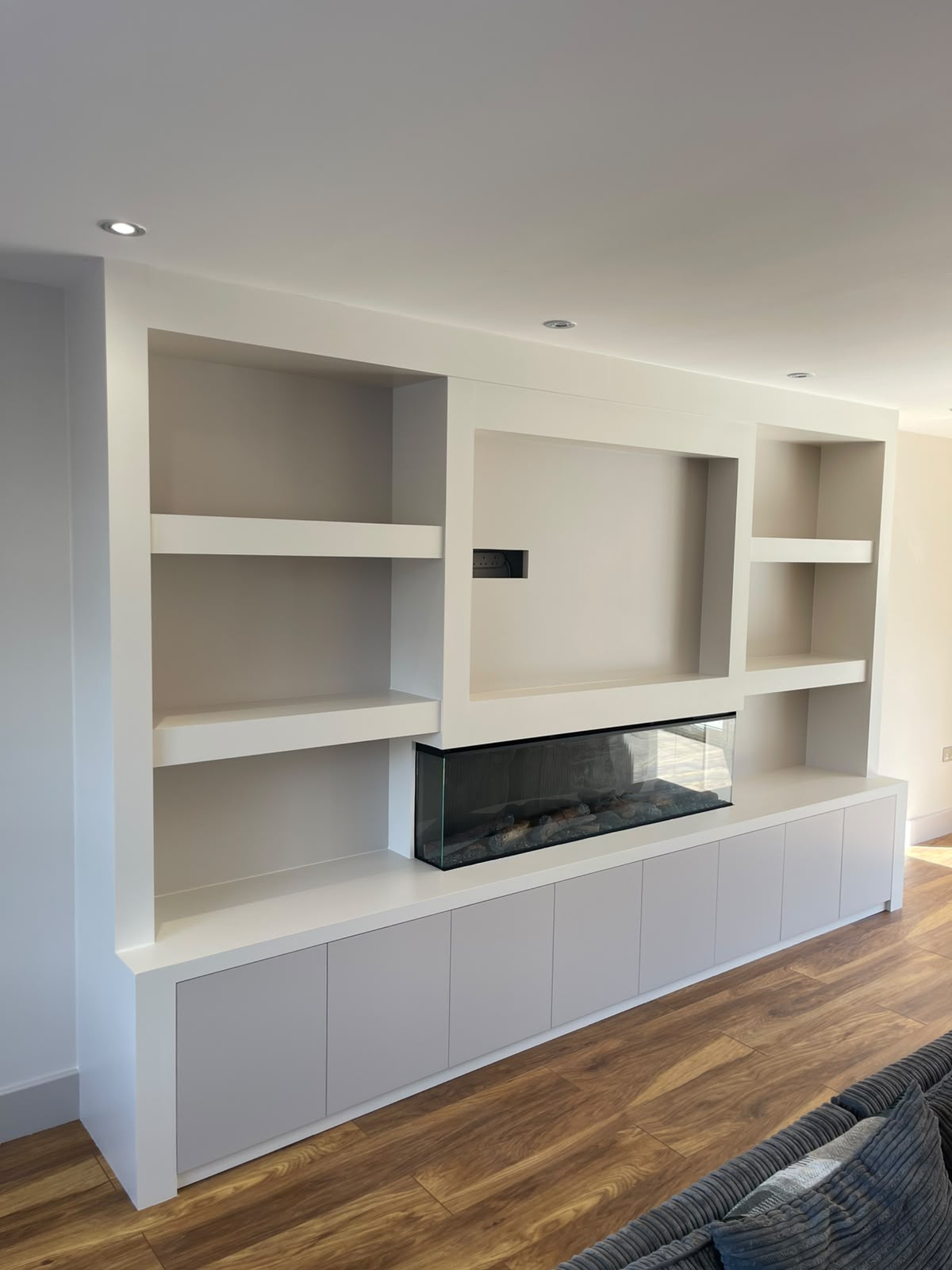 White media wall with alcove shelving and inset linear fireplace