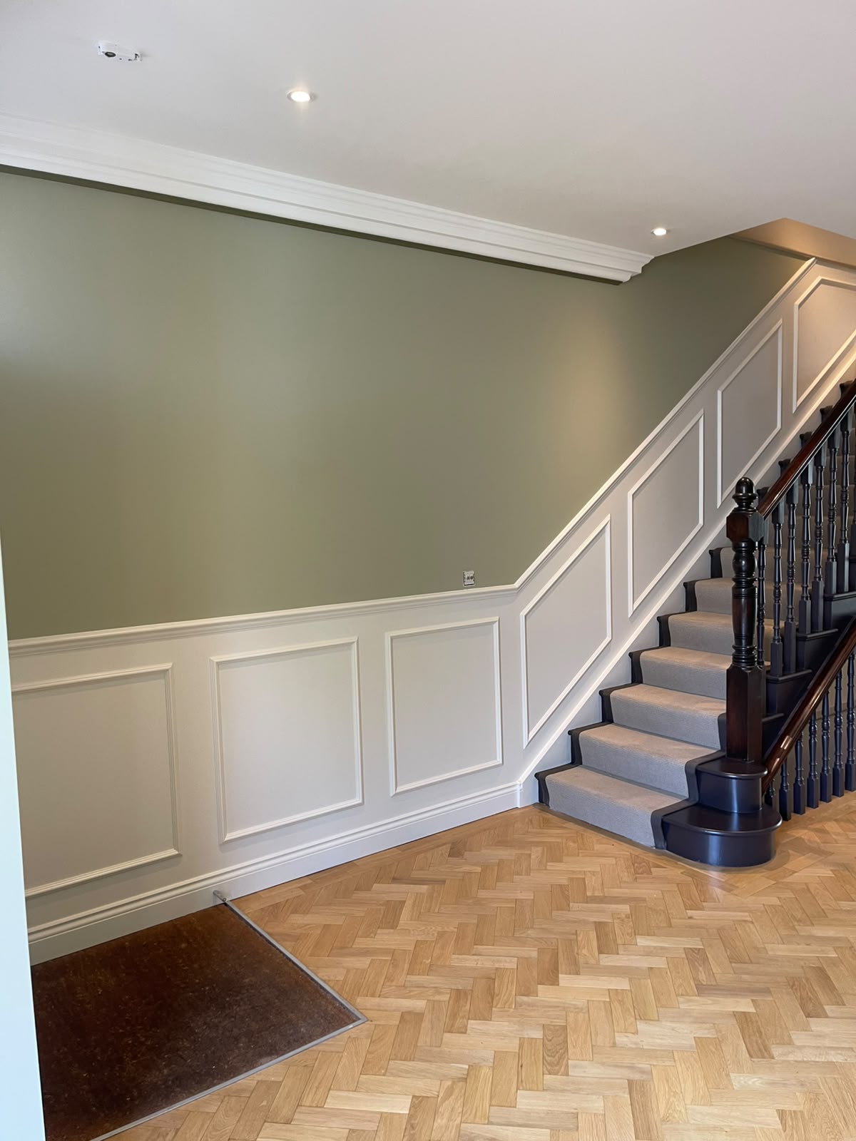 Elegant hallway with sage green walls and white panelled wainscoting by GPD Property Service