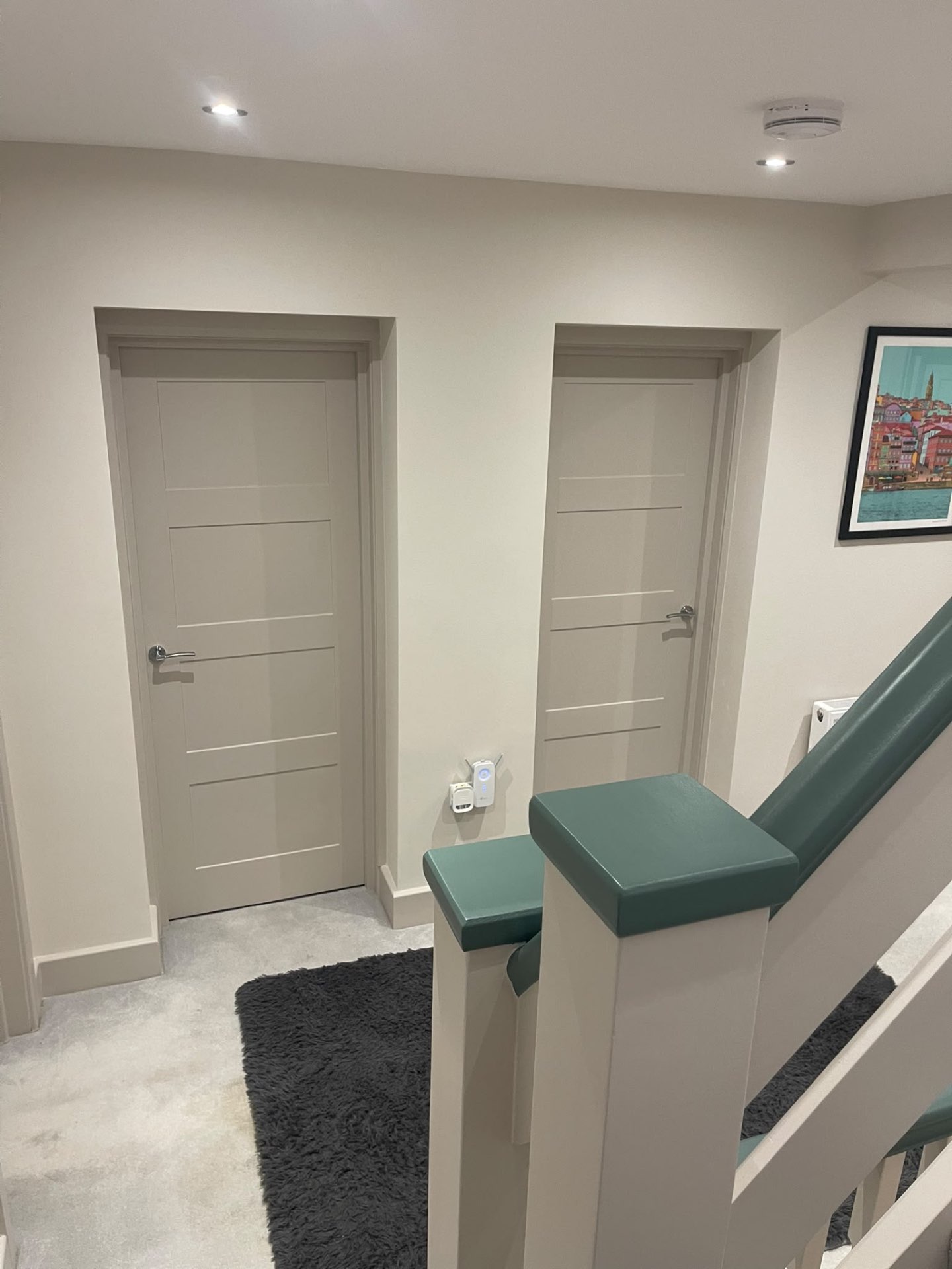 Finished hallway doors beside staircase woodwork with contrasting dark green details in Hersham