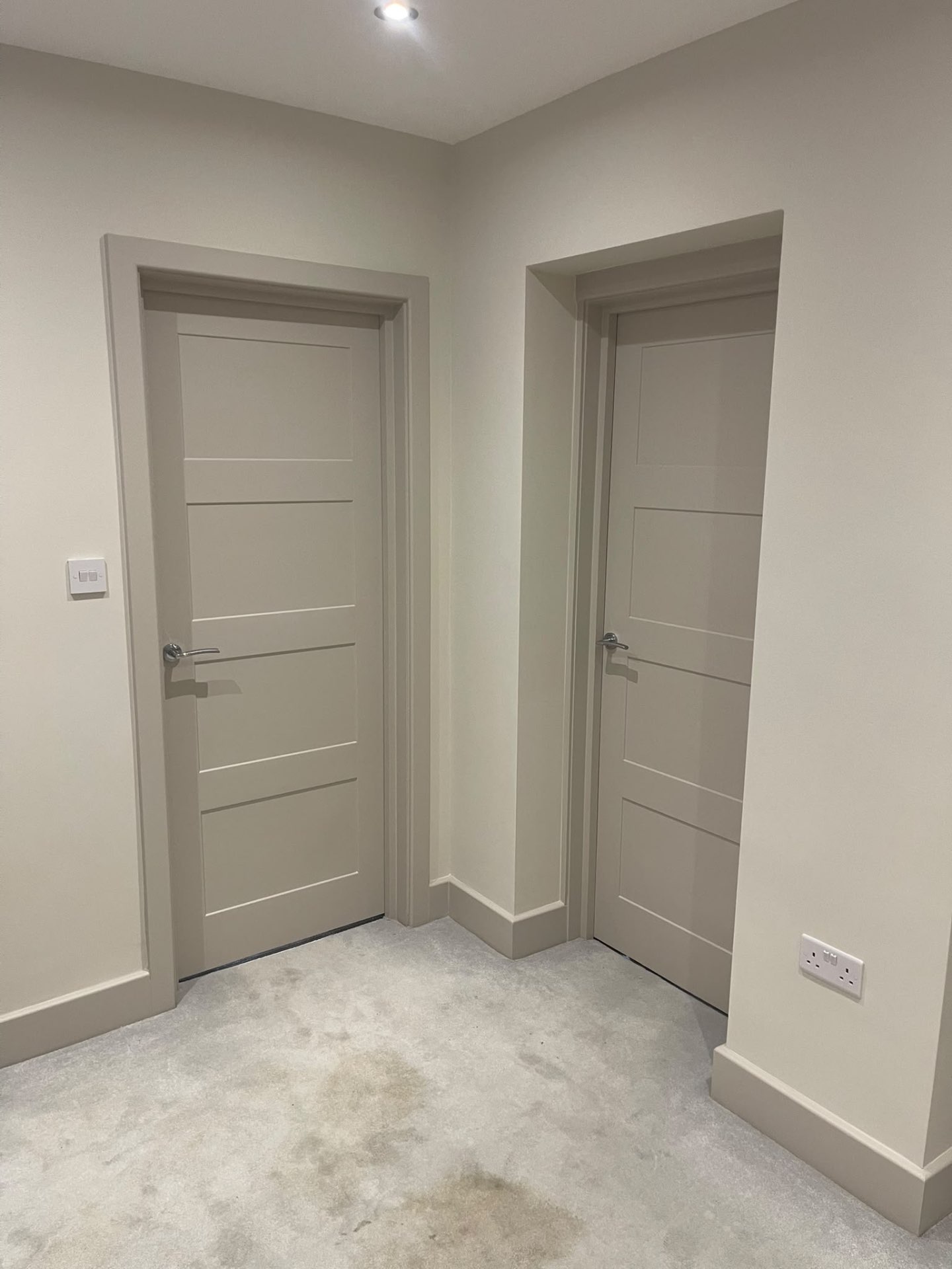 Two painted interior doors with matching frames and skirting boards in a Hersham hallway