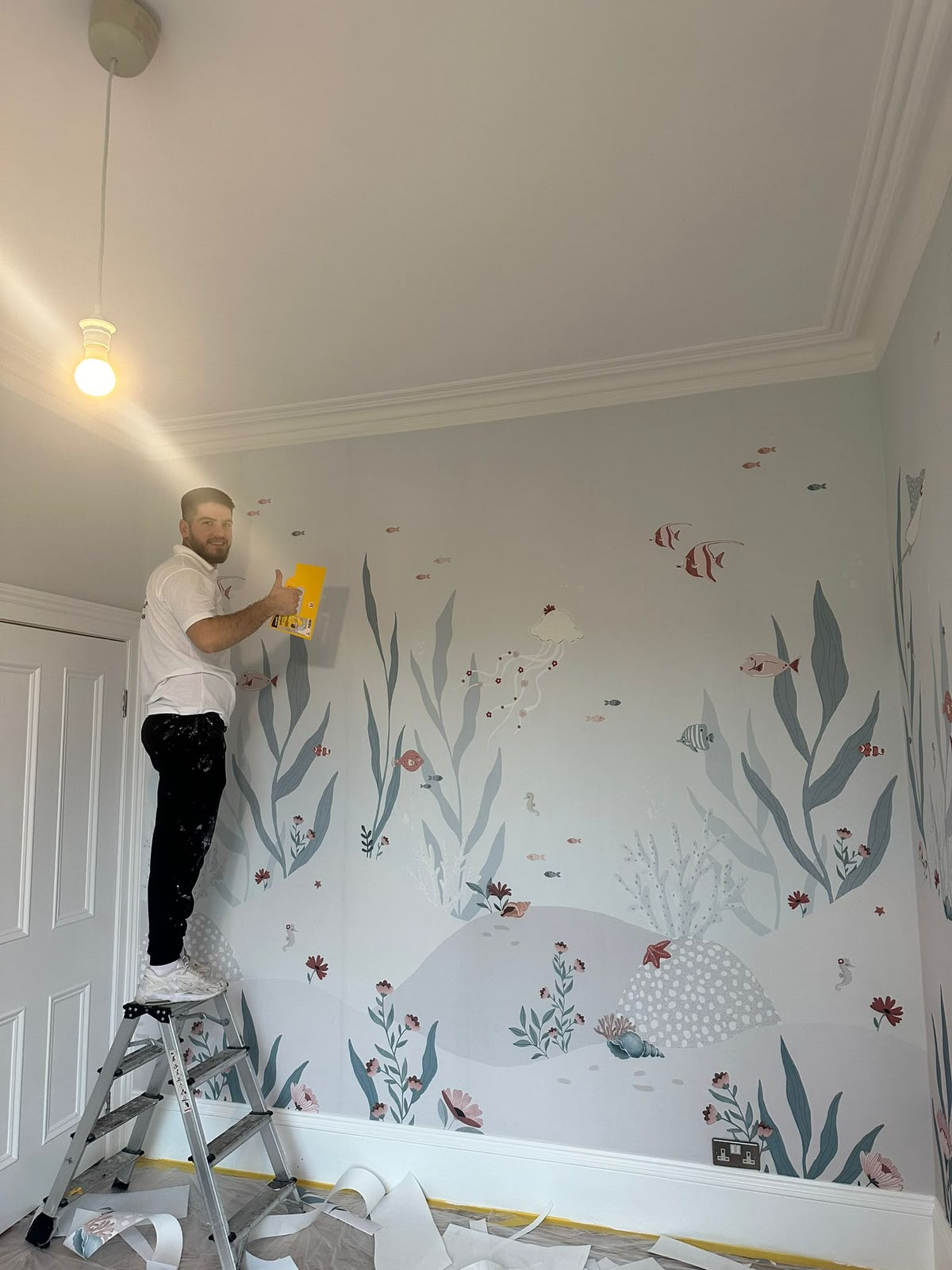 Child's bedroom with an under-the-sea mural of fish, coral and seaweed