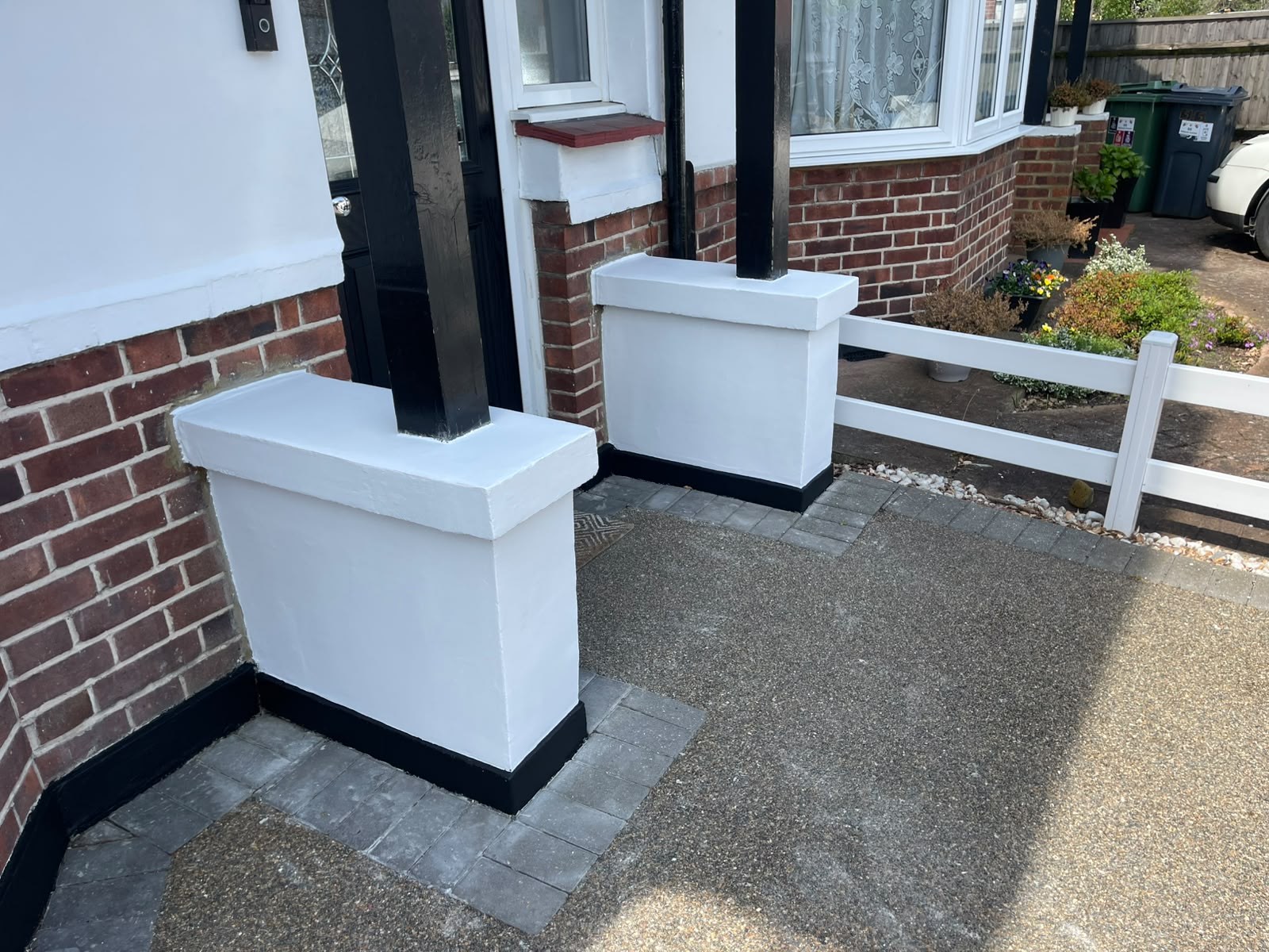 Freshly painted white porch pillars with crisp black trim