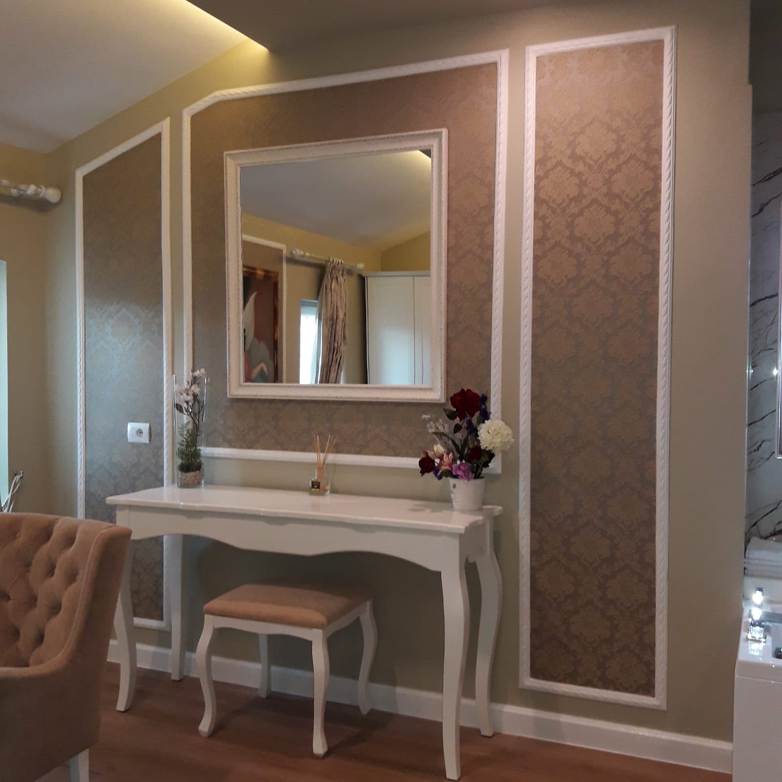 Drawing room with tan damask wall panels outlined in white moulding