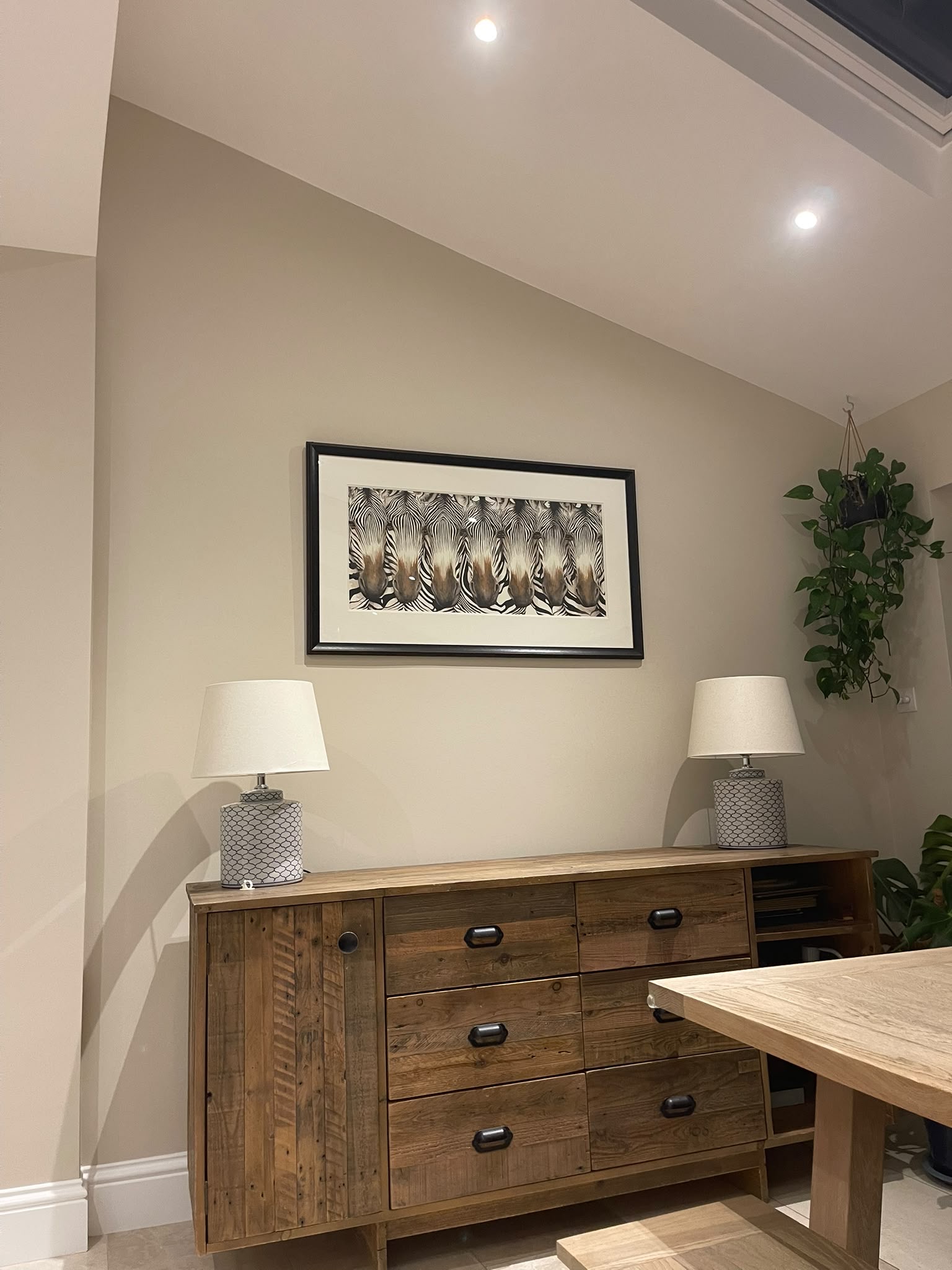 Freshly painted wall and sloped ceiling above a dining room sideboard