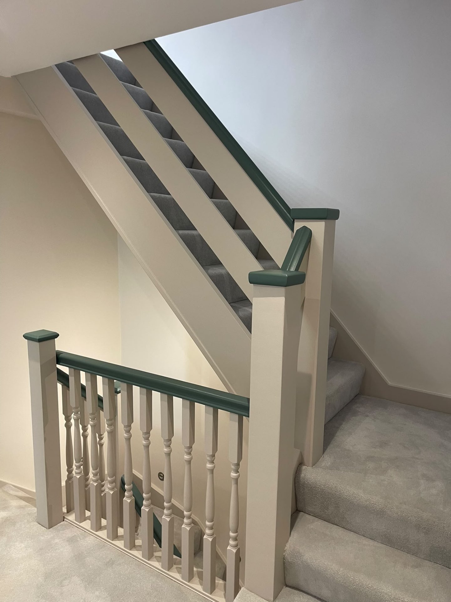 Completed Hersham staircase with painted woodwork, walls and contrasting dark green handrail