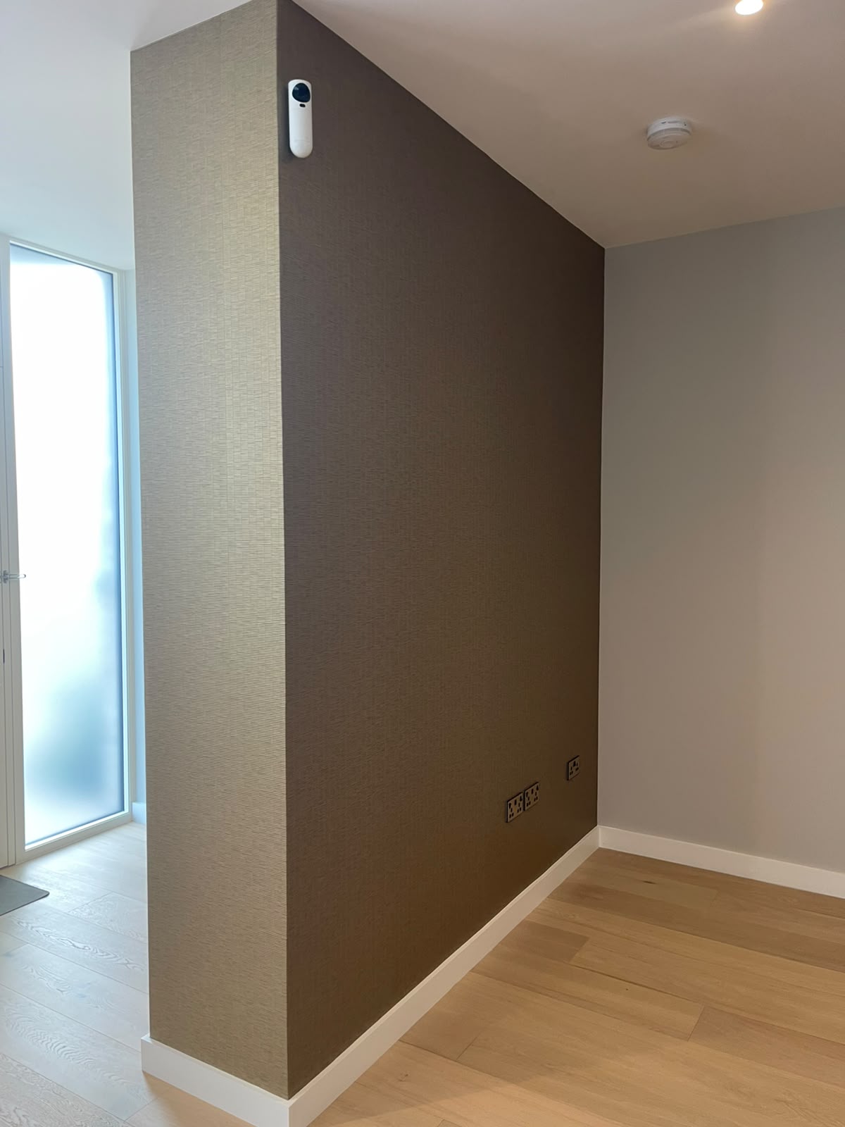 Hallway feature wall in warm brown textured grasscloth wallpaper
