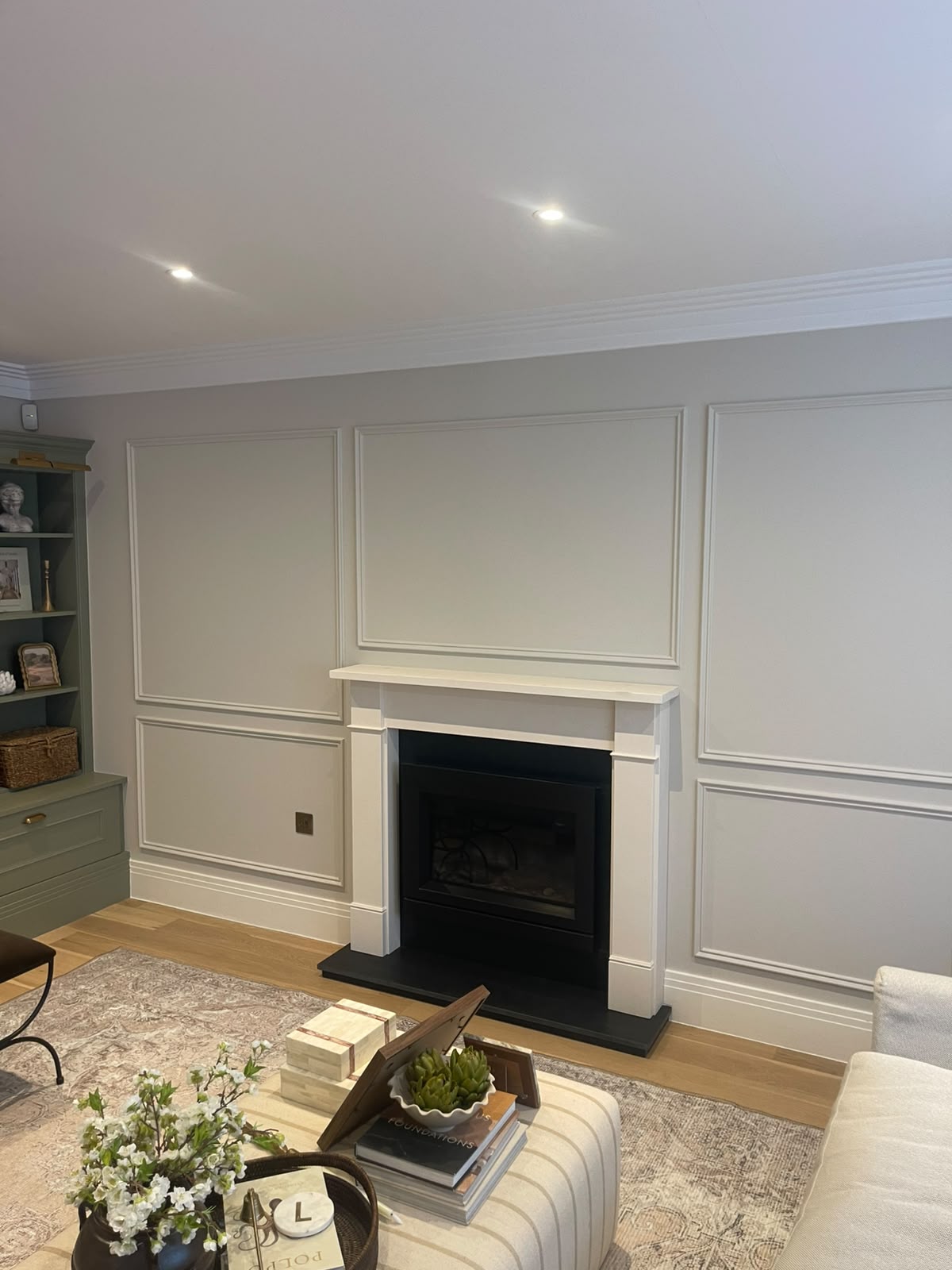 Painted decorative wall panelling framing a living room fireplace in Hinchley Wood