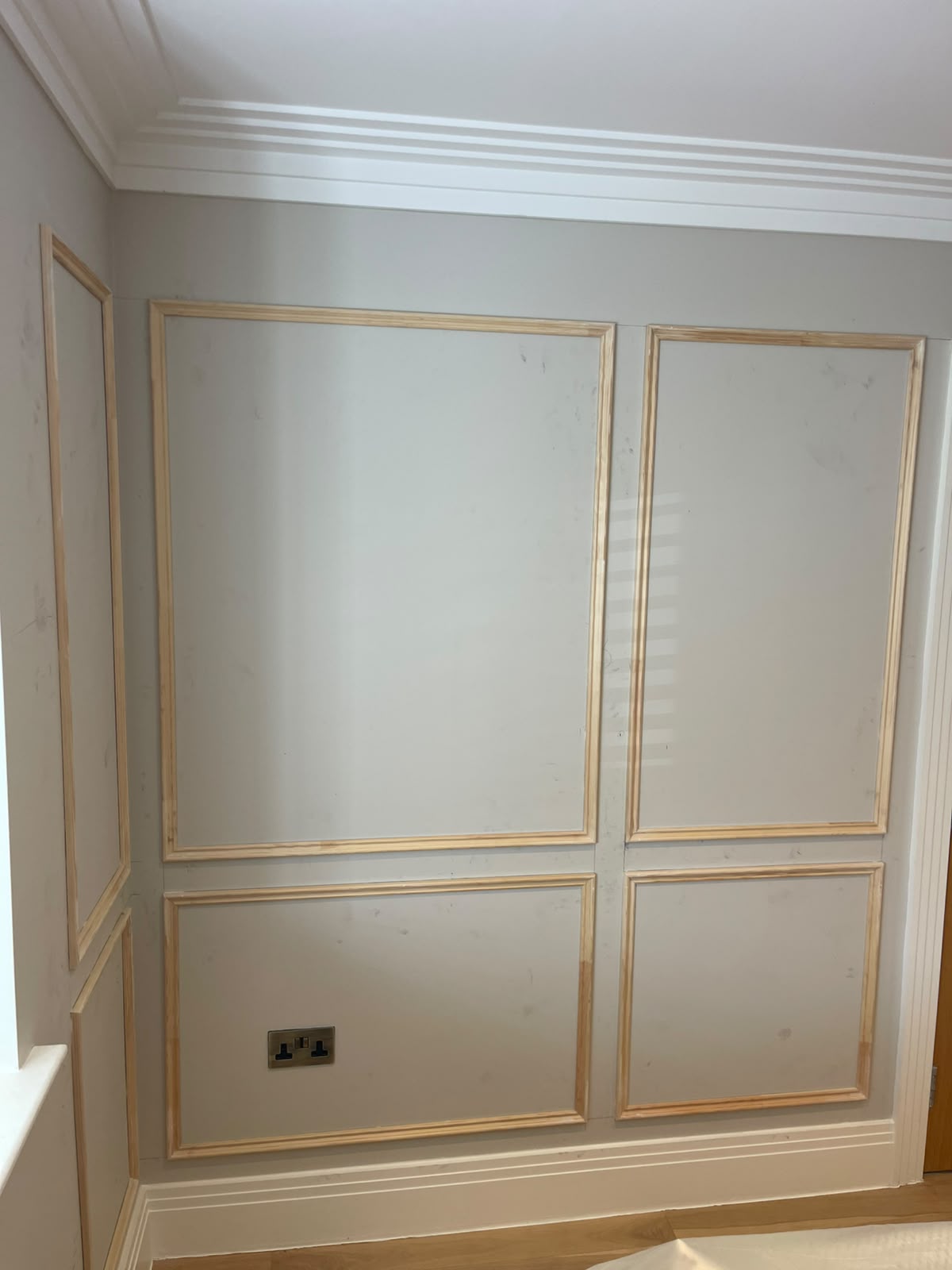 Unpainted timber wall mouldings during decorative panelling installation in Hinchley Wood